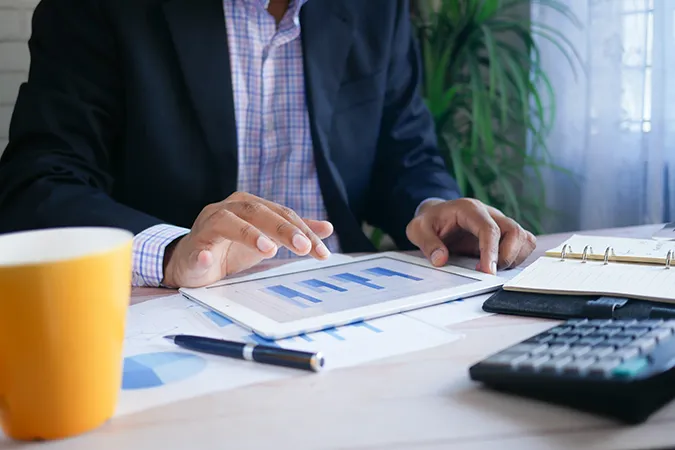 Man working on claim reports with a cup of coffee on his desk.