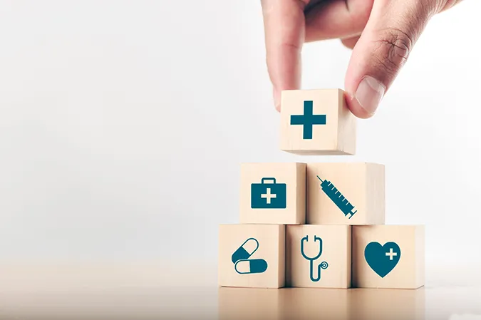 Whole person care represented by blocks with medical symbols on them.